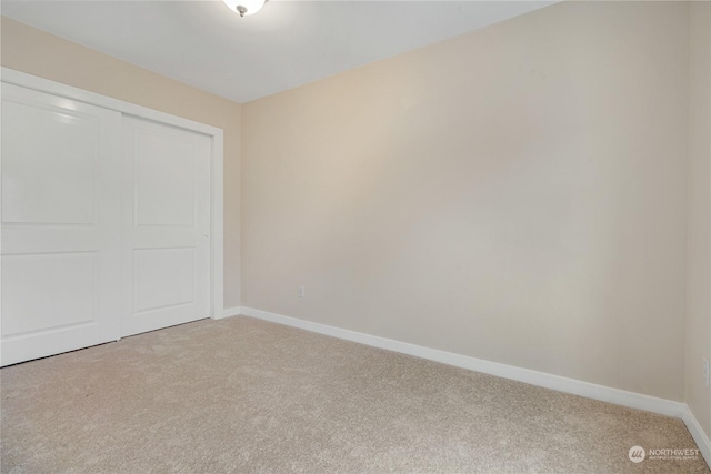 unfurnished bedroom featuring a closet and light carpet