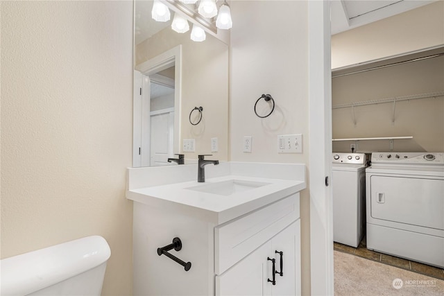 bathroom featuring vanity, toilet, and washing machine and dryer