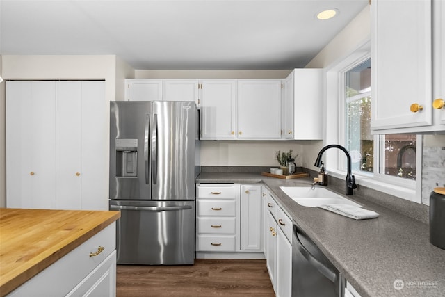 kitchen featuring stainless steel appliances, white cabinetry, sink, and dark wood-type flooring