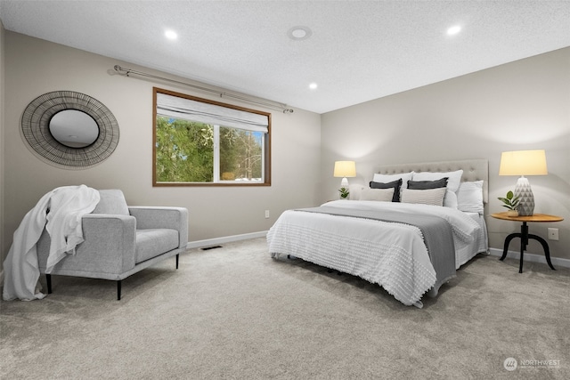 bedroom featuring light carpet and a textured ceiling