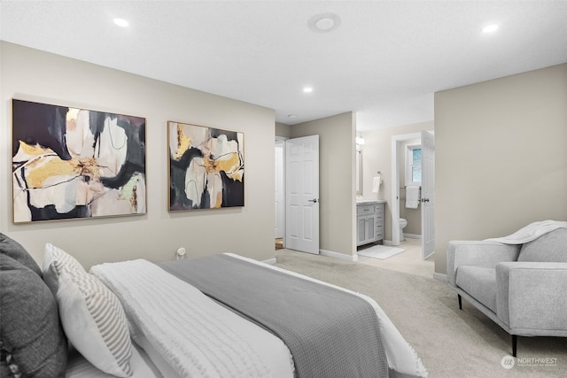 bedroom featuring ensuite bathroom and light colored carpet