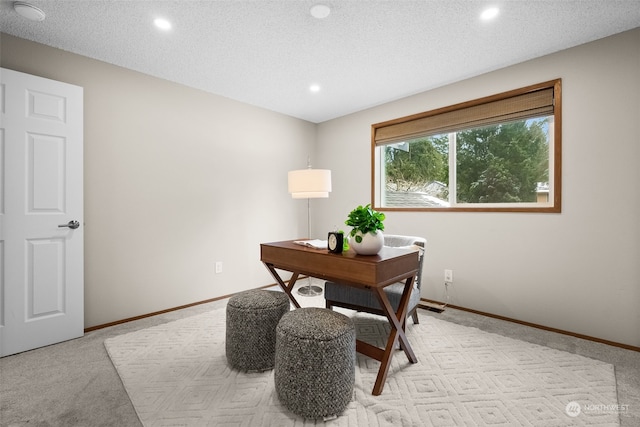 carpeted home office with a textured ceiling