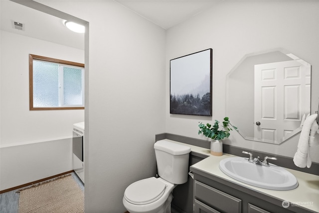 bathroom featuring vanity, toilet, and hardwood / wood-style floors