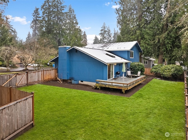 rear view of house featuring a yard and a deck