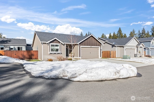 ranch-style home featuring board and batten siding, fence, and driveway