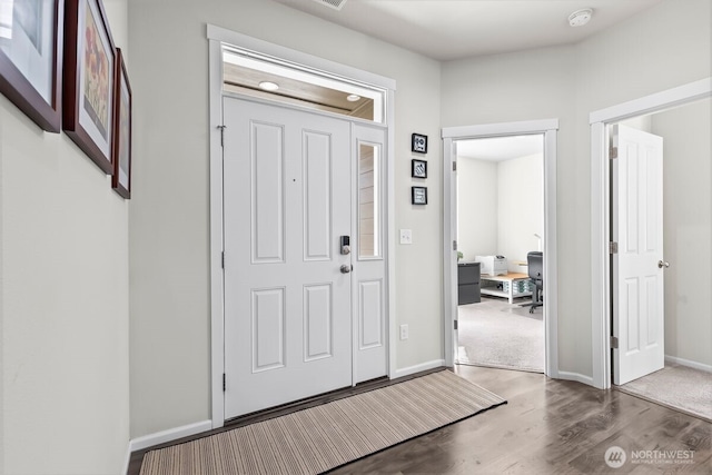 foyer entrance with wood finished floors and baseboards