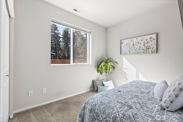 bedroom with carpet floors, visible vents, and baseboards