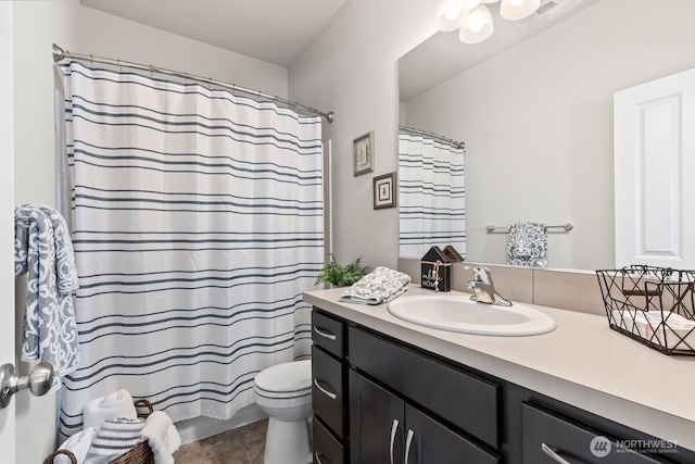 bathroom featuring toilet, visible vents, a shower with shower curtain, and vanity