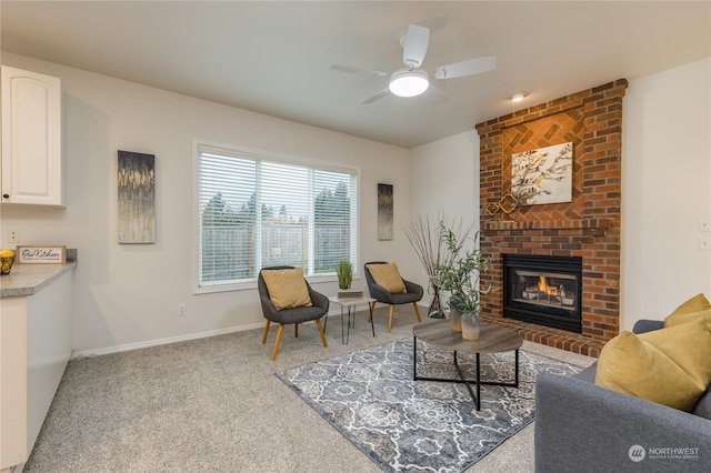 carpeted living room with a brick fireplace and ceiling fan