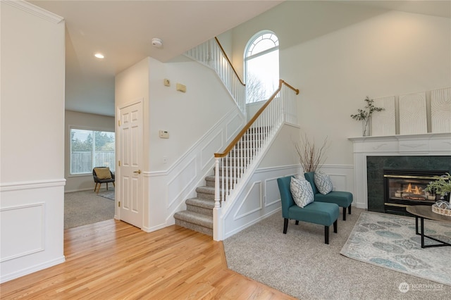 stairs featuring a high end fireplace and hardwood / wood-style floors