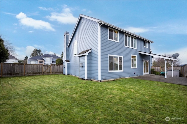 rear view of property featuring a yard and a patio area