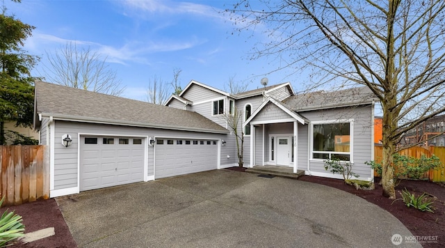 view of front of house with driveway, a shingled roof, fence, and an attached garage