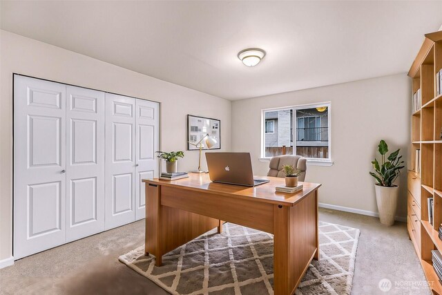 office space with light carpet and baseboards