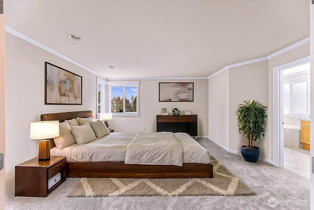 bedroom featuring baseboards, ornamental molding, ensuite bathroom, and light colored carpet