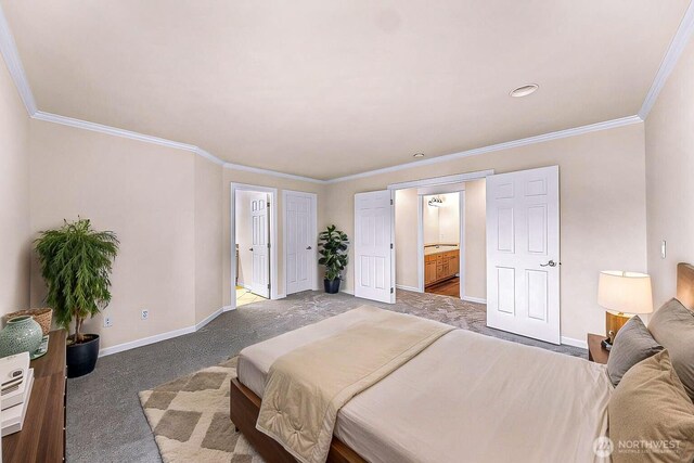 carpeted bedroom featuring ornamental molding, baseboards, and ensuite bathroom