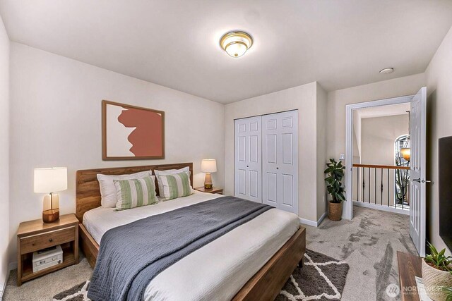 bedroom featuring a closet, light carpet, and baseboards