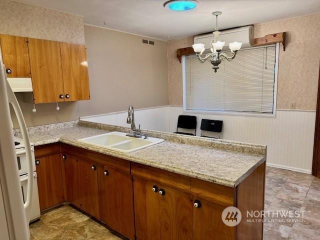 kitchen with hanging light fixtures, sink, and kitchen peninsula