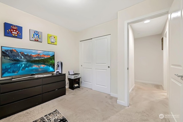 bedroom with light carpet and a closet