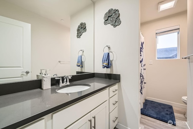 bathroom with vanity, toilet, and hardwood / wood-style floors