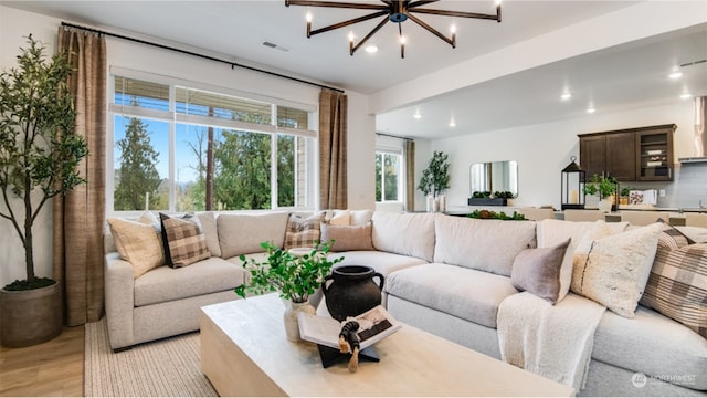 living room featuring a chandelier and light hardwood / wood-style floors