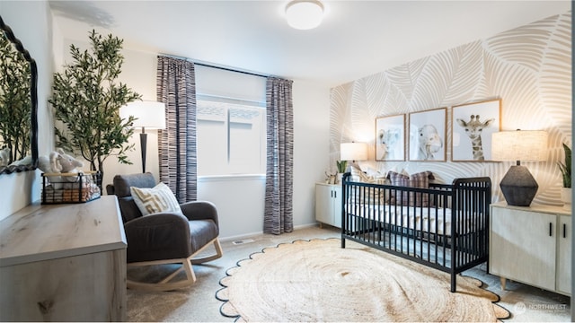 bedroom featuring a nursery area and carpet flooring