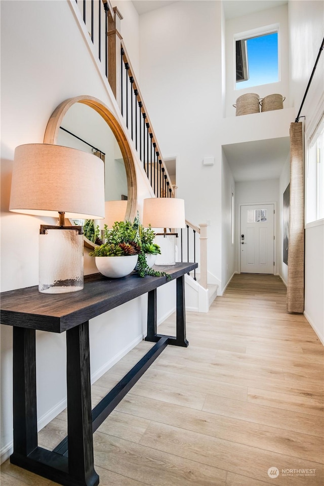 entryway with a high ceiling and light hardwood / wood-style floors