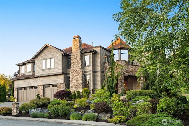 view of front of house featuring driveway, stone siding, a balcony, and a garage