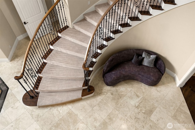 stairs featuring a high ceiling and baseboards