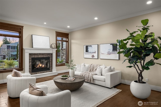 living area featuring baseboards, ornamental molding, and dark wood finished floors