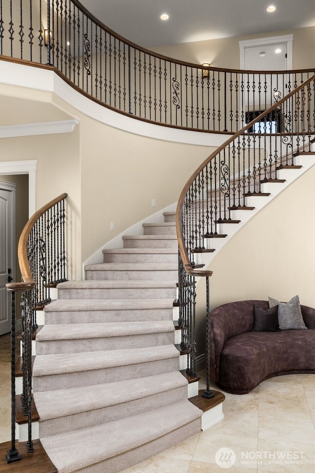 staircase with recessed lighting and a high ceiling