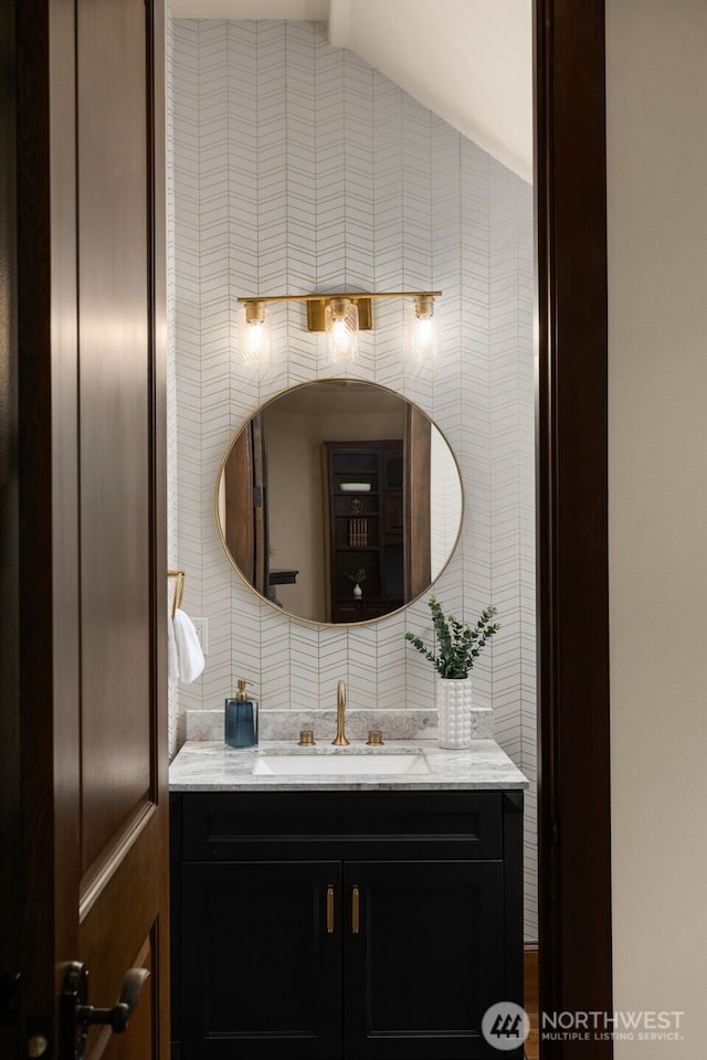 bathroom featuring decorative backsplash, vaulted ceiling, tile walls, and vanity