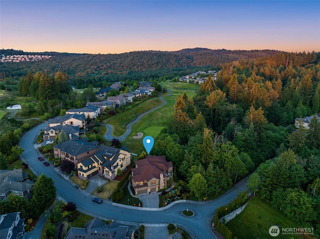 aerial view at dusk with a residential view and a forest view