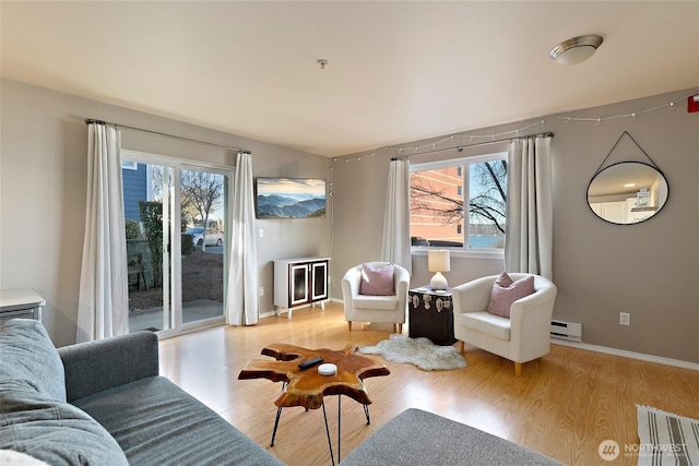 living room with a baseboard radiator and light hardwood / wood-style floors