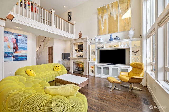 living room with dark wood-type flooring and a high ceiling