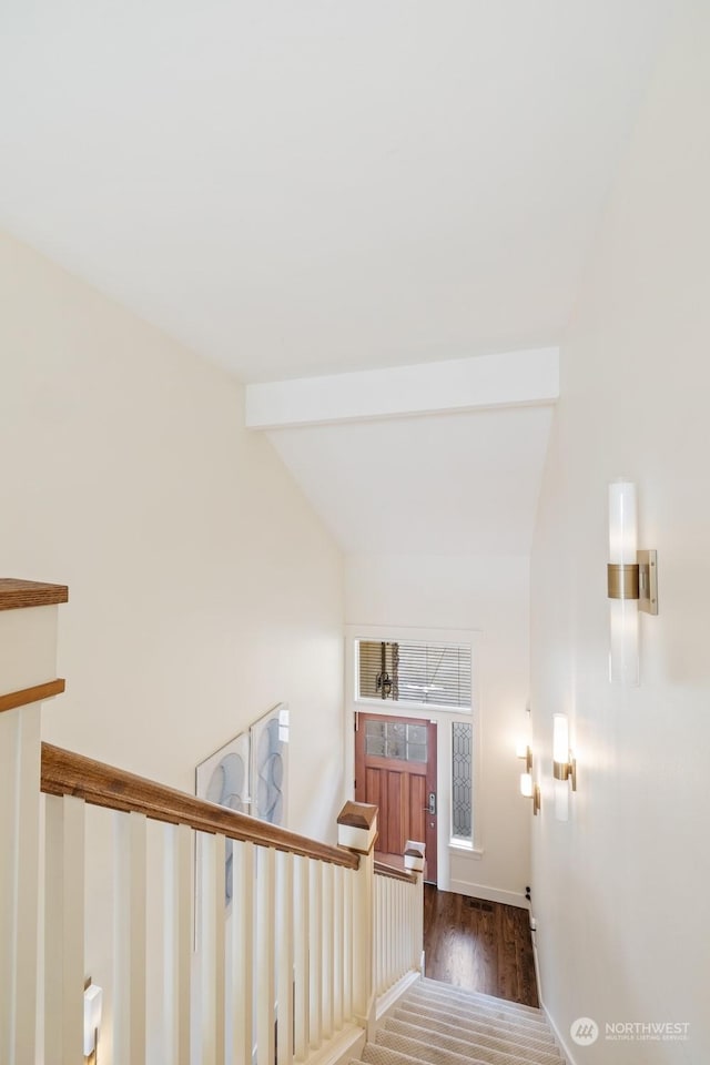 stairs featuring hardwood / wood-style flooring and beam ceiling