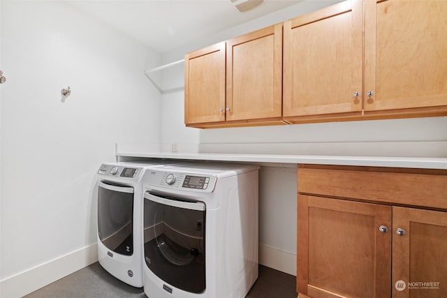 laundry room featuring cabinets and washer and clothes dryer