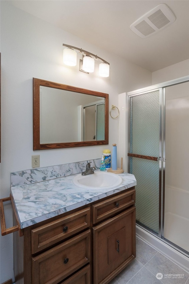 bathroom with vanity, an enclosed shower, and tile patterned floors