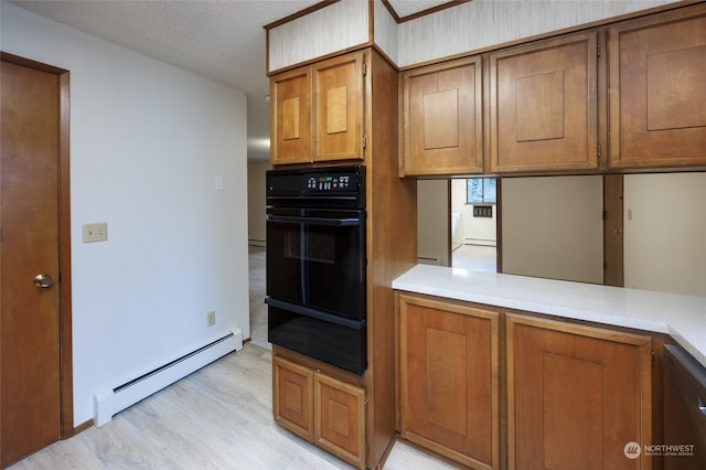 kitchen featuring light hardwood / wood-style flooring, baseboard heating, black appliances, a textured ceiling, and kitchen peninsula