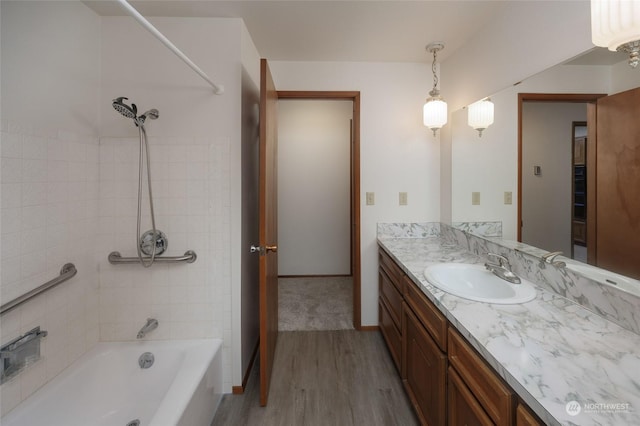 bathroom featuring hardwood / wood-style flooring, vanity, and tiled shower / bath combo