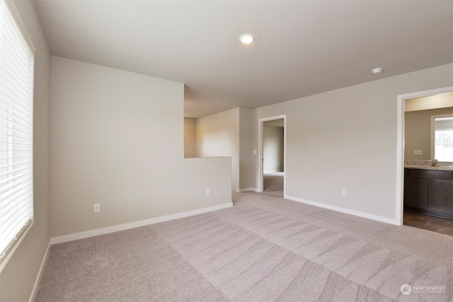 empty room featuring light carpet and sink