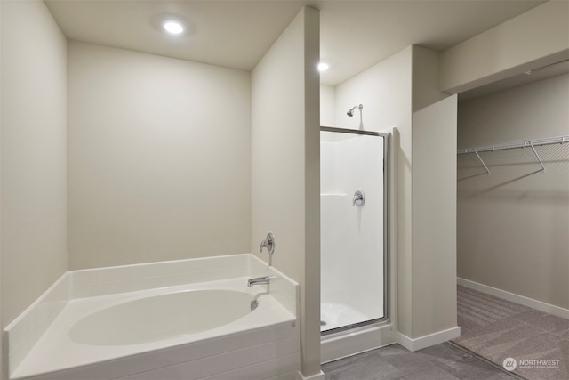 bathroom featuring shower with separate bathtub