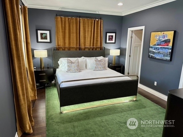 bedroom featuring ornamental molding and dark hardwood / wood-style flooring