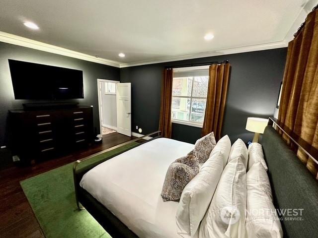 bedroom featuring ornamental molding and dark wood-type flooring