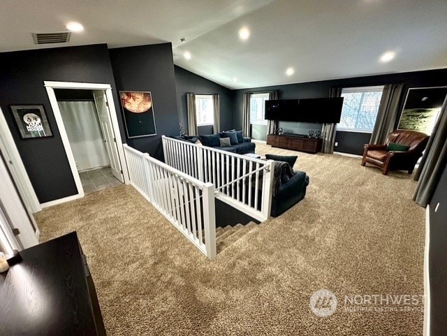 carpeted home theater room with lofted ceiling