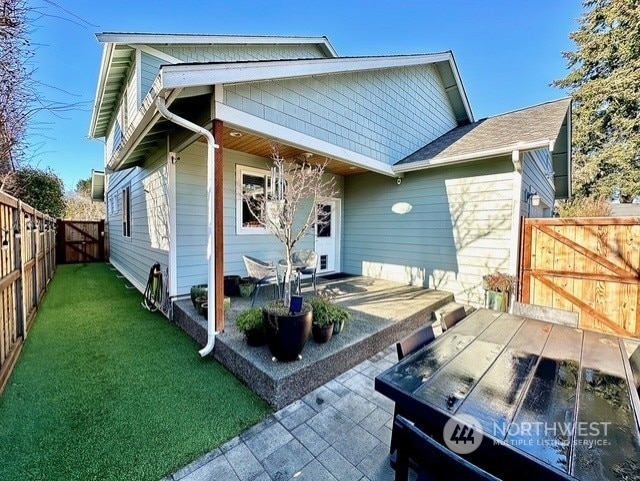 back of house featuring a lawn and a patio