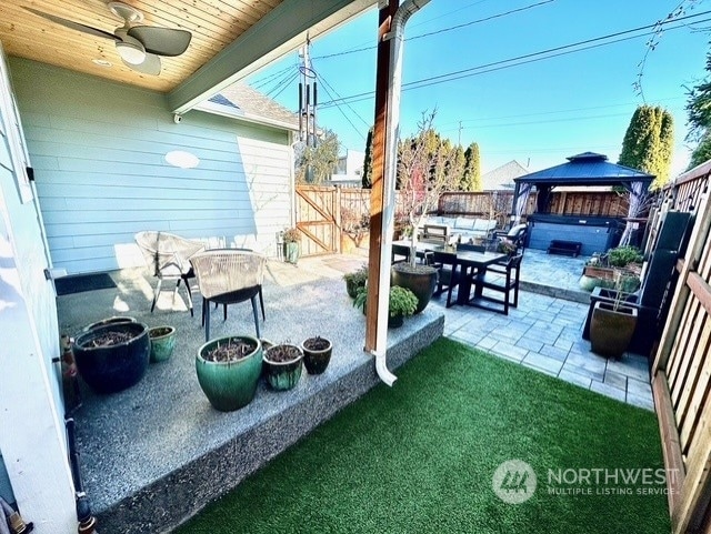 view of patio featuring a hot tub, a gazebo, and ceiling fan