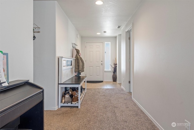 hall with light colored carpet