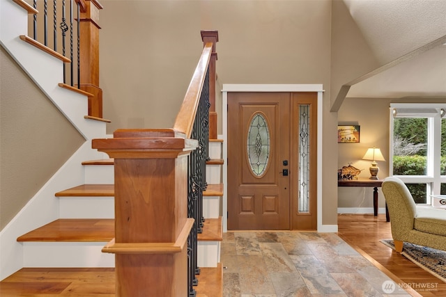 foyer entrance featuring stairway, wood finished floors, and baseboards