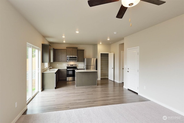 kitchen featuring stainless steel appliances, hardwood / wood-style floors, a center island, and sink