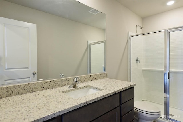 bathroom featuring vanity, toilet, and walk in shower